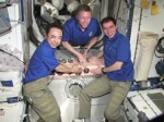 Commander Mike Fossum (center) and Flight Engineers Sergei Volkov (right) and Satoshi Furukawa attach the Expedition 29 patch inside the station. (Credits: NASA)