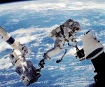 Astronaut David Wolf attaches a camera to ISS with help from Canadarm2 on a 2002 EVA (Credits: NASA/Science Photo Library).
