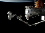 JAXA astronaut Aki Hoshide floats on the end of the station's robotic arm on his first spacewalk (Credits: NASA).