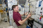 Mission Specialist Rex Walheim works on the BRIC-SyNRGE experiment aboard space shuttle Atlantis during the STS-135 mission (Credits: NASA/QinetiQ North America).