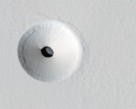 View of a skylight that opens into a Martian cave at the Pavonis Mons volcano, as photographed by the Mars Reconnaissance Orbiter (Credits: NASA).