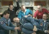 ISS crew help astronaut Tom Marshburn turn a quick flip at his daughter's request (Credits: NASA).