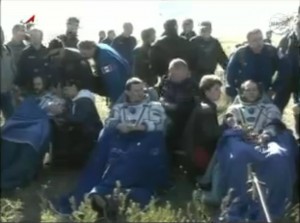 Expedition 35 crew, seated, catch their breath after landing. From left: Chris Hadfield, Roman Romanenko, and Tom Marshburn (Credits: Roscosmos/NASA).