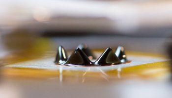 L. Brad King's prototype of a ferrofluid ion thruster. When subjected to voltage, the points of the crown arise from a ring-shaped trench circling a 2.54 cm block of aluminum (Credits: Sarah Bird).