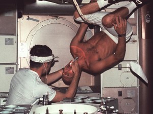 Skylab 2 commander Pete Conrad undergoes a dental examination by medical officer Joseph Kerwin in the Skylab Medical Facility. In the absence of an examination chair, Conrad simply rotated his body to an upside down position to facilitate the procedure. (Credits: NASA).