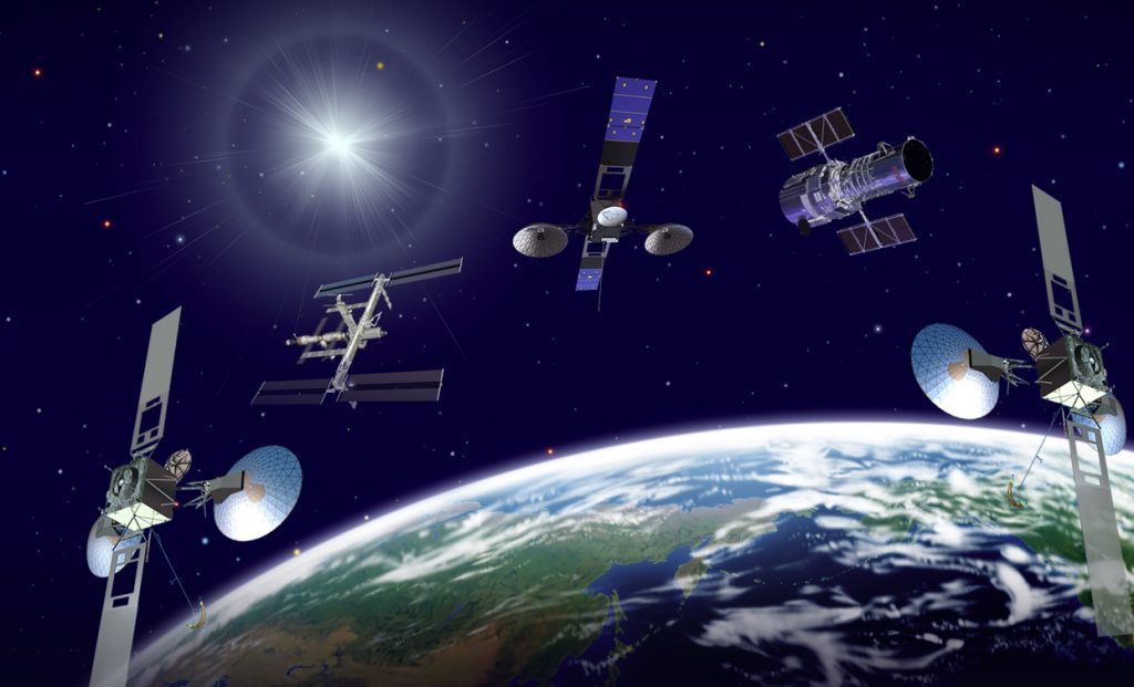 Artist's view of three Tracking and Data Relay Satellites (TDRS), the ISS and Hubble Space Telescope orbiting Earth. - Credits: NASA/Goddard Space Flight Center.