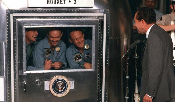 President Richard M. Nixon welcomes the Apollo 11 astronauts aboard the U.S.S. Hornet, already confined to the Mobile Quarantine Facility (MQF). The quarantine requirement was eliminated following Apollo 14 once it was proven that the Moon was void of pathogens and there was no risk of “back” contamination; redits - NASA