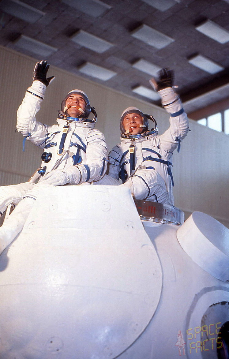 Commander Vyacheslav Zudov (left) and Flight Engineer Valeri Rozhdestvensky, clad in their pressure suits, are pictured with a Soyuz mockup during training. Photo (Credits: Joachim Becker / SpaceFacts.de).