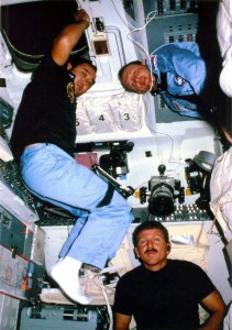 In one of relatively few images ever publicly released from Mission 51C, astronauts Loren Shriver (bottom), Ellison Onizuka (left), and Jim Buchli pose for a photograph in Discovery’s flight deck (Credits: NASA).