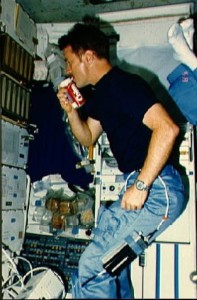 An astronaut drinks Coca Cola from a specially designed can which was flown on the shuttle, yet the carbonated space beverage produced unwanted stomach effects in microgravity. Credits: (NASA)