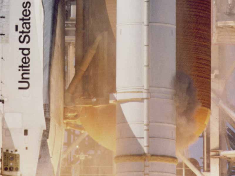 A plume of grey smoke near the aft attach strut on the right Solid Rocket Booster. - Credits: NASA.
