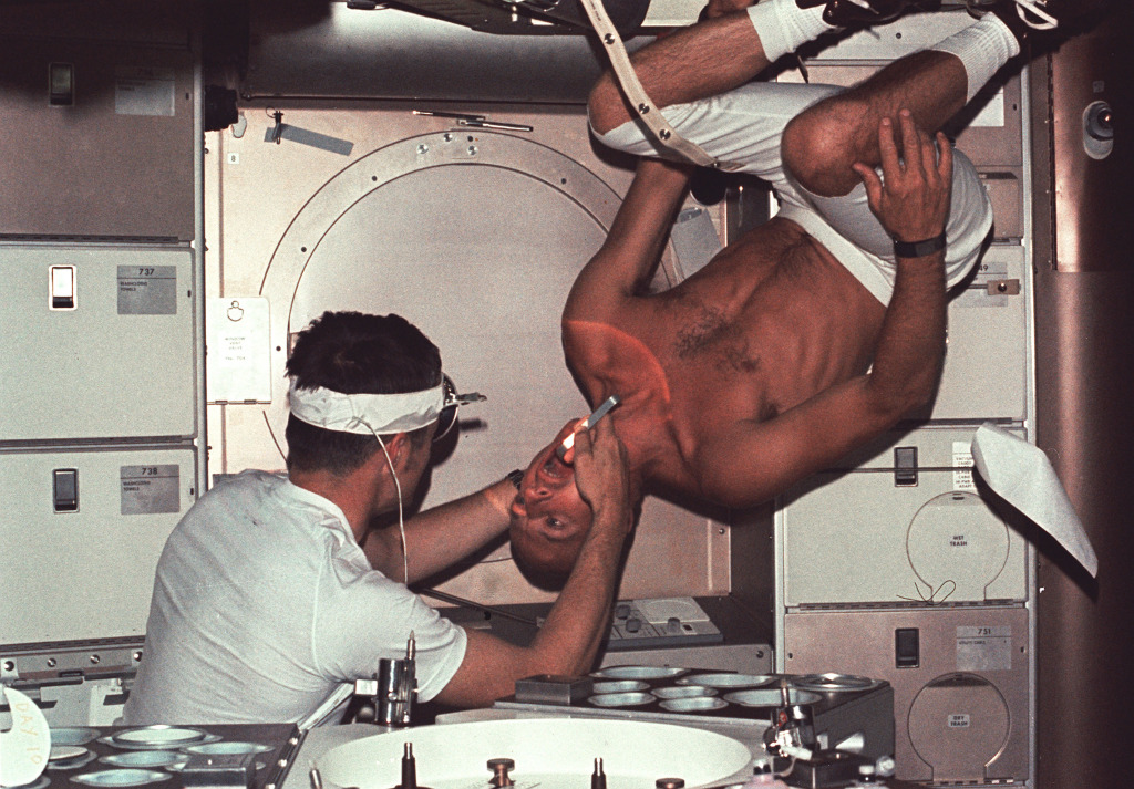 Skylab 1 commander Pete Conrad undergoes a dental examination by medical officer Joseph Kerwin