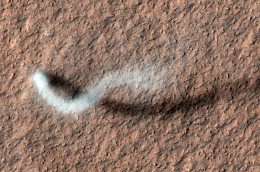 A towering dust devil casts a serpentine shadow over the Martian surface in this image acquired by the High Resolution Imaging Science Experiment (HiRISE) camera on NASA's Mars Reconnaissance Orbiter. The length of the dusty whirlwind's shadow indicates that the dust plume reaches more than half a mile (800 meters) in height. The plume is about 30 meters in diameter. Credits: NASA/JPL-Caltech/University of Arizona