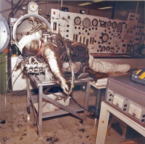 THIS SIDE VIEW REVEALS THE EXTENT OF THE DAMAGE TO THE ENTIRE EMU. YOU ALSO GET SOME IDEA OF THE LIMITED ESCAPE OPTIONS THAT WERE AVAILABLE TO THE TECHNICIANS WHO WERE AROUND THE EMU WHEN THE FIRE ERUPTED. credits: NASA