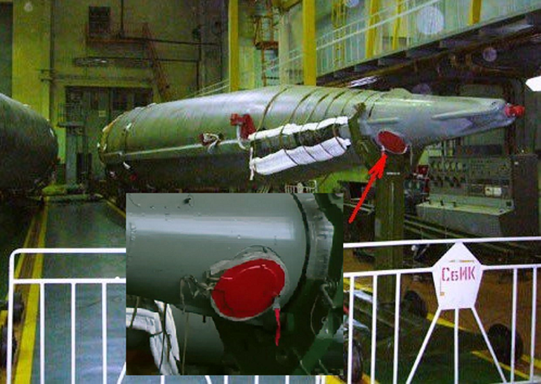 Fig. 4 - Location of the nozzle on the lateral booster oxygen tank (the red cover is a temporary protection). The nozzle lid is pyrotechnically actuated during booster separation. In the insert you can see the harness used to ground the pyro during production. Credit: kik-sssr.ru & IAASS